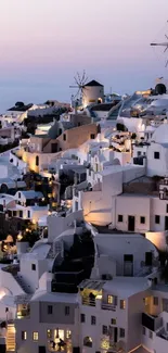 Santorini white buildings at sunset with windmills.