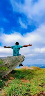 Person on rock under bright blue sky, surrounded by scenic nature.