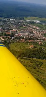 Aerial view of landscape with yellow plane wing.