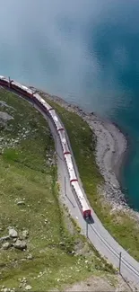 Aerial view of train by a turquoise lake in the Alps