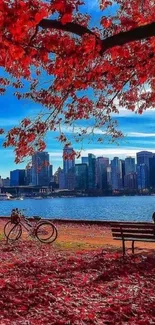 Autumn cityscape with red leaves and skyline view over water.