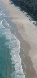 Aerial view of a tranquil beach with turquoise waves and lush greenery.