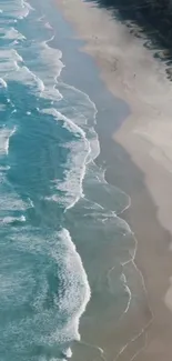 Aerial view of beach with ocean waves and sandy shore.