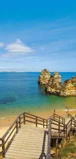 Scenic view of beach with wooden stairs and blue sky.