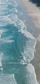 Aerial view of ocean waves gently crashing on a serene sandy beach.