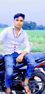 Motorcycle parked in a lush green field with a serene countryside backdrop.