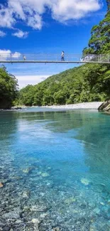 Scenic view of a blue river with a sky bridge and lush green forest.