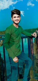 Mobile wallpaper with a green-shirted man against a blue sky and natural setting.