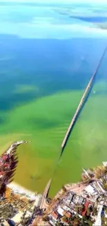 Aerial view of a long bridge spanning clear blue and green waters, ideal for wallpapers.