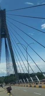 Bridge with cables under a blue sky and clouds.