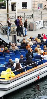 Copenhagen canal tour with people on a boat in vibrant urban setting.