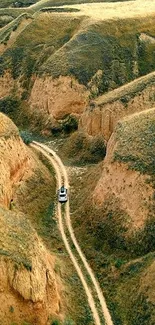 SUV on a winding road through scenic canyon landscape.