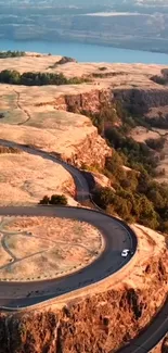 Aerial view of a winding road in a scenic canyon landscape.