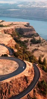 Winding road through a scenic canyon landscape with river view.