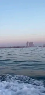 Scenic view of a city skyline with tranquil water in the foreground, under a blue sky.