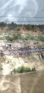 Crowded gathering on a scenic rocky cliffside landscape.