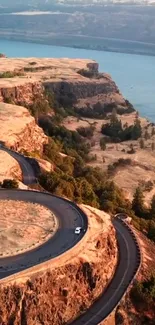 Aerial view of winding road on scenic cliffs by the water.