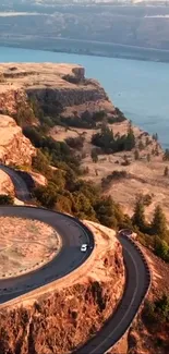 Aerial view of winding road on cliffs by a river.