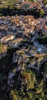 Aerial view of a quaint village on a cliff with lush greenery around it.