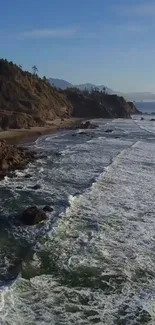 A serene coastal beach with waves crashing on rocky shores under a blue sky.