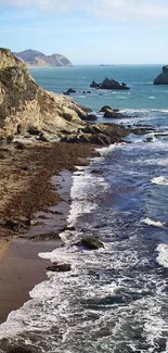 Scenic coastal beach with waves crashing along the rocky shoreline and cliffs.