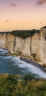 Scenic view of cliffs and sea at sunset with a pastel sky.