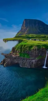 Scenic cliffside with waterfall flowing into ocean under blue sky.