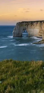 Stunning coastal cliff with sunset over ocean waves.