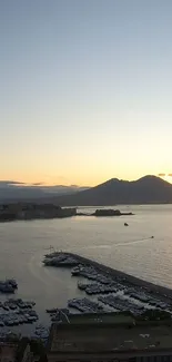 Scenic evening coastal view with mountains and calm sea at sunset.