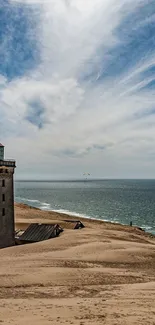 Lighthouse on sandy coast with blue sky.