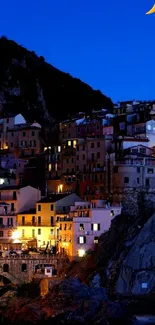 Coastal village under crescent moon at night, vibrant buildings against deep blue sky.