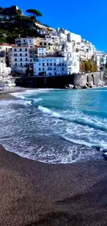 Scenic view of a Mediterranean seaside town with turquoise waters and sandy beach.