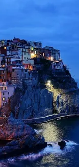 Serene coastal village at dusk with illuminated homes and blue waters.