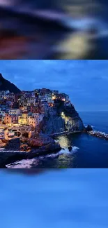 Twilight view of a coastal village with illuminated houses on the cliffs.