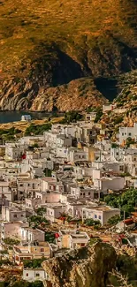 Coastal village with white buildings against rugged cliffs.