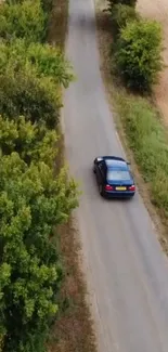 Car driving on a scenic country road surrounded by greenery.