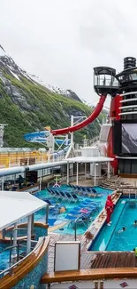 Cruise ship pool with mountain views and waterslide.