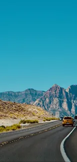 Mobile wallpaper featuring a scenic desert highway with mountains.