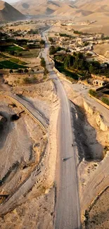 Aerial view of a desert landscape with road and village.