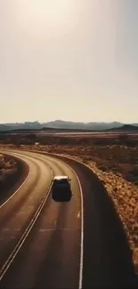 Desert road with lone car under a sunny sky, showcasing scenic adventure.