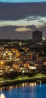 Evening cityscape with lights and a calm river under a twilight sky.