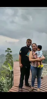 Family standing on a deck with lush green scenery in the background.