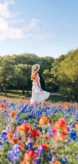 A woman in a white dress stands in a colorful flower field under a blue sky.