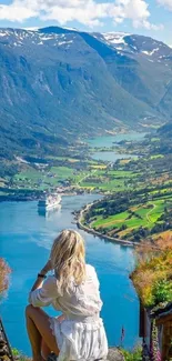 Woman overlooking scenic fjord landscape with vibrant colors and mountains.