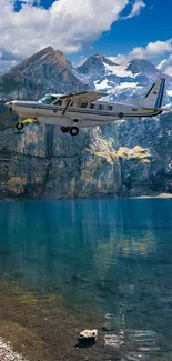 Airplane flying over mountains and lake under clear sky.