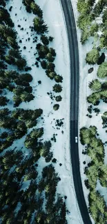 Aerial view of a snowy forest road in winter.