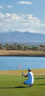 Golfers on a scenic course with mountains and clear sky.