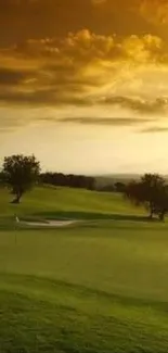 Serene golf course at sunset under a vibrant orange sky.