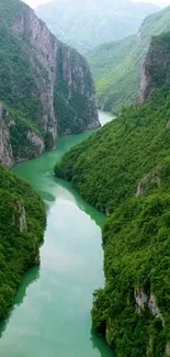 Lush green river flowing through steep mountainous valley.