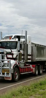 Powerful truck on scenic highway with cloudy skies.